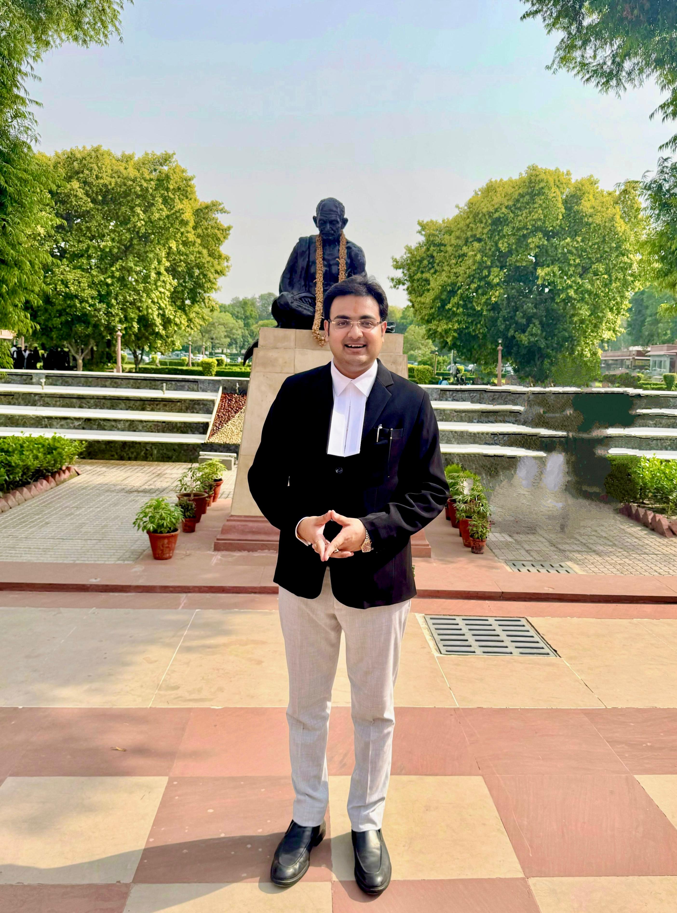 Portrait in advocate robes before Gandhi statue